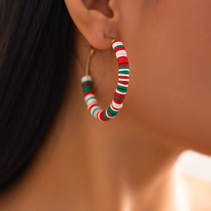Close-up of Christmas hoop earrings with red green and white beads on model