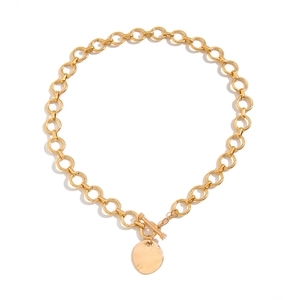 Dettaglio della collana a catena dorata con pendente tondo lucido e chiusura a T