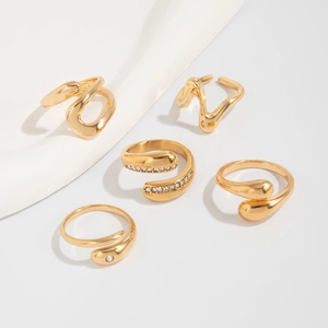 Detailansicht von fünf goldenen unregelmäßigen geometrischen Ringen mit Zirkonia-Besatz