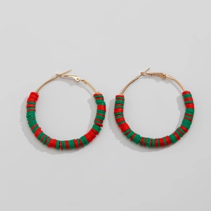 Detailed macro view of Christmas themed red and green clay beads on gold hoop earrings