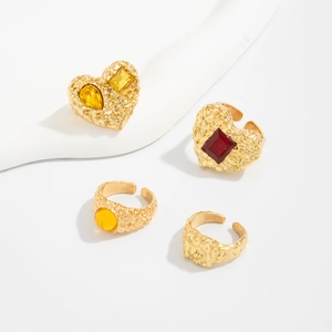 Detail von Vintage Goldringen und Herzschmuck mit Edelsteinen und Lavatextur