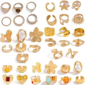 Goldenes Set unregelmäßiger Edelsteinringe mit Blumen und nautischen Anhängern
