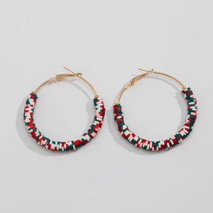 Detail of festive gold hoop earrings with red, white, and green polymer clay accents