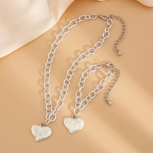 Dettaglio della collana con ciondolo a cuore di lava argento e bracciale a catena spessa