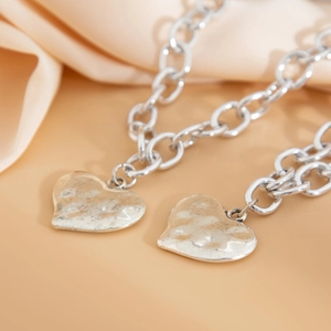 Dettaglio dei pendenti a cuore in metallo argentato su una collana a catena spessa