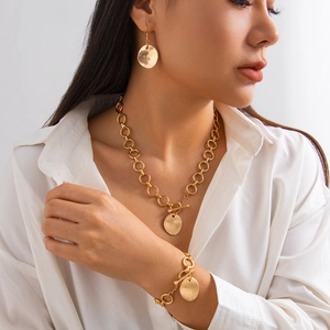 Set di gioielli con collana pendente cuore di lava e finitura dorata martellata su una modella