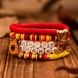 Makro-Detail von mehrlagigen Erntedankfest-Perlenarmbändern mit Happy Thanks Schriftzug