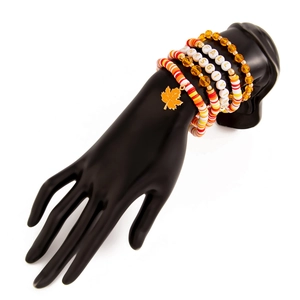 Detail view of Thanksgiving beaded bracelet set with maple leaf charm on hand model