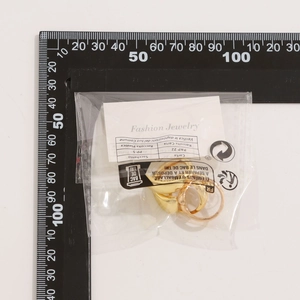 Mesure du set de bagues goutte dorées montrant le diamètre sur une règle noire en L