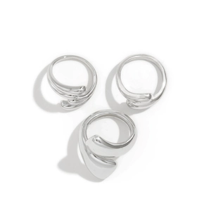 Vue détaillée de trois bagues en argent poli au design fluide et minimaliste moderne