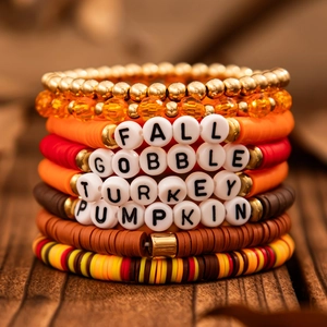 Detail of colorful Thanksgiving beaded bracelets with turkey charms and autumn themed words