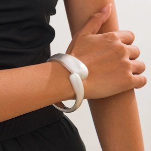 Close-up of minimalist silver wide open cuff bracelet on wrist for trendy style