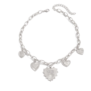 Detailed view of silver lava heart pendants with diverse textures on a chunky chain