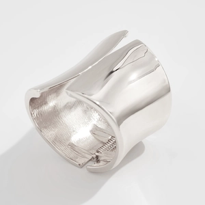 Macro detail of silver metal spring cuff bracelet showing polished surface and hinge