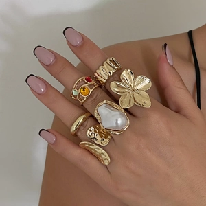 Close-up of 7pcs gold ring set featuring baroque pearls and colorful gemstones on fingers
