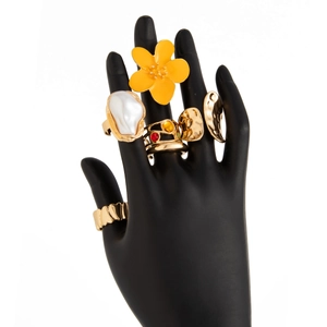 Detail view of five gold rings featuring baroque pearls, gemstones and floral designs