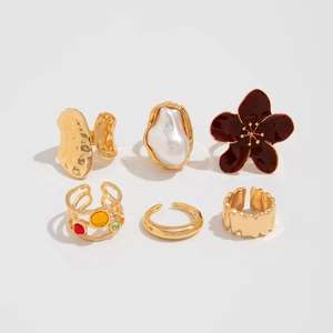 Detailed set of six gold rings featuring a red enamel flower and baroque pearl design