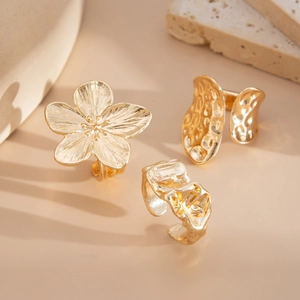 Detailed macro view of three textured gold-plated floral and irregular organic rings set