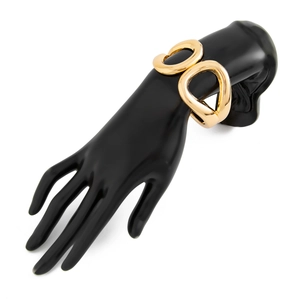 Detail of interlocking chunky gold metal rings with a polished finish on a bracelet