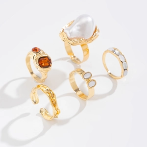 Detailed view of a 5-piece gold-plated ring set with baroque pearl and amber stones