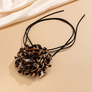 Dettaglio della collana con fiore leopardato in tessuto e cordino nero a più strati