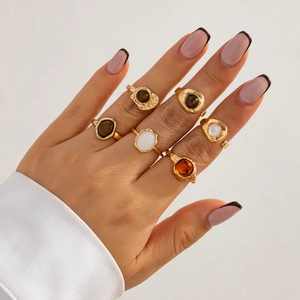 Close-up of vintage gold rings set with baroque pearls and amber gems on model hand