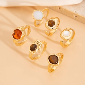 Macro detail of six gold adjustable rings with vintage gemstones and baroque pearls