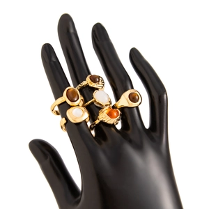 Detail of vintage gold-plated ring set with oval colorful gemstones on a model hand