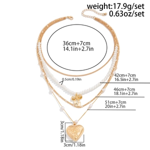 Detailed view of 4-layer gold necklace set with pearl bow and embossed heart lock pendant