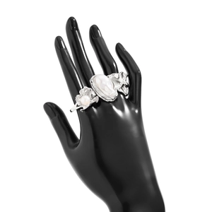 Détail macro d'une bague argentée style lave avec grande perle baroque sur un modèle de main