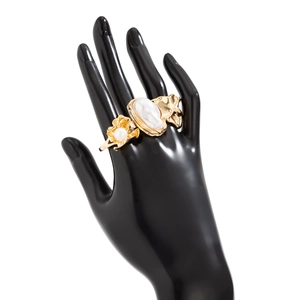 Détail d'une bague perle baroque avec texture métal liquide sur un présentoir de main