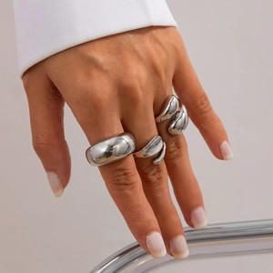 Détail des bagues en métal liquide argenté avec perles baroques sur les mains du mannequin