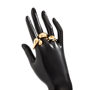 Détail d'une bague goutte d'eau dorée au design métal liquide sur une main de mannequin
