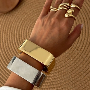 Minimalist wide metal spring bangle and organic gold rings with mirror finish for women