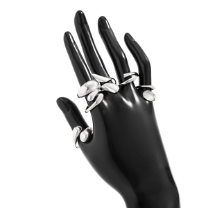 Bague artistique en métal liquide argenté au design fluide sur un modèle de main noir