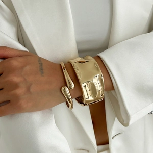 Minimalist gold liquid metal textured cuff bracelet set with glossy finish on wrist
