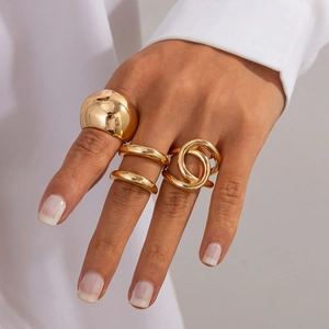 Détail de trois bagues dorées avec design dôme bulle, double rangée et style géométrique