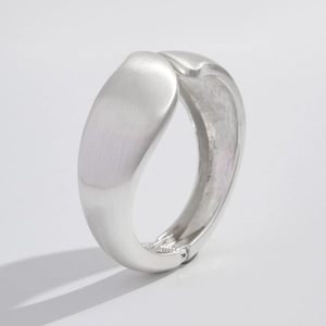 Minimalist matte silver teardrop bangle with a brushed metal finish and hinged closure