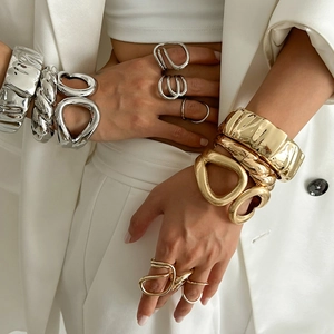 Golden and silver textured metal bracelets and rings with organic pleated designs