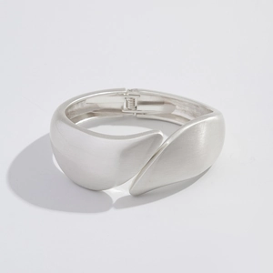 Detail of silver matte bracelet with brushed metal texture and hinged opening design