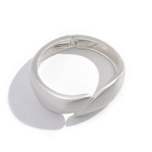 Detail of silver matte textured wide bangle featuring a cross wrap teardrop design