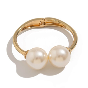 Golden multi-layer spring cuff bracelet featuring two large elegant pearls on white background