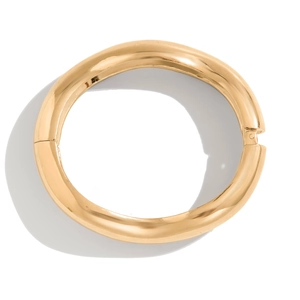 Macro detail of golden irregular teardrop cuff bracelet with polished metal mirror finish