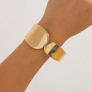 Brazalete abierto de oro martillado pulido con acabado de espejo brillante en la muñeca mujer