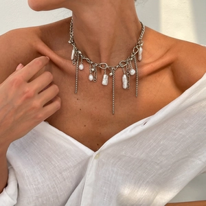 Dettaglio della collana a maglie d'argento con perle barocche su modella con camicia bianca