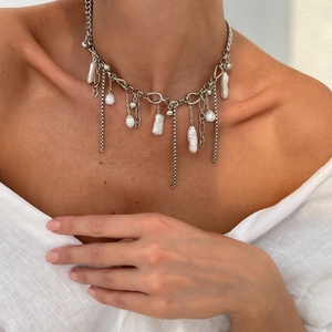 Dettaglio della collana a strati argentata con perle barocche su una modella