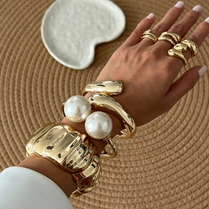 Barockperlen-Armbänder und gewellte Goldmanschettenringe mit elegantem Metallic-Finish