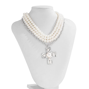 Detail of multi-layer pearl necklace with a hammered liquid metal cross pendant and pearls