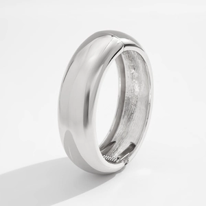 Detailed view of silver metal wide bangle with mirror finish and spring hinge closure