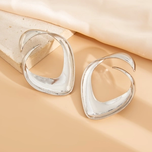 Artistic silver bow earrings with hollow fluid design displayed on a textured stone base